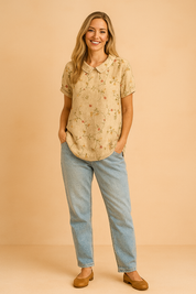 Blouse met korte mouwen en een beige achtergrond, versierd met subtiele geborduurde takjes en kleine roze bloemetjes in een vintage bloemenpatroon.