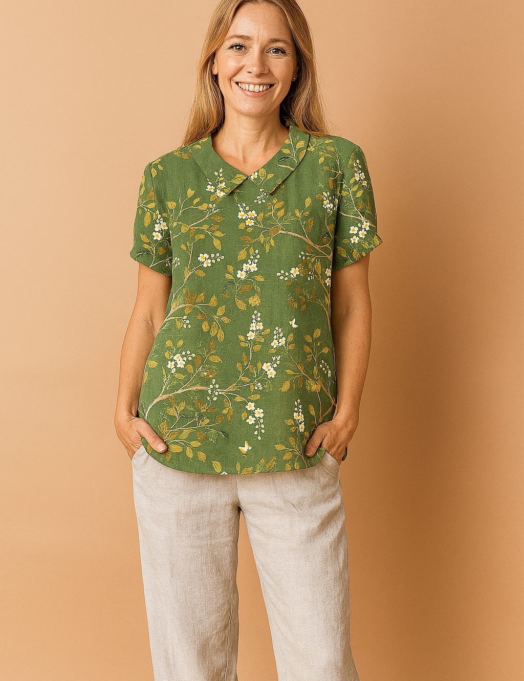 Donkergroene linnen blouse met korte mouwen, versierd met goudgele takken en witte bloesems in een sierlijk geborduurd patroon.