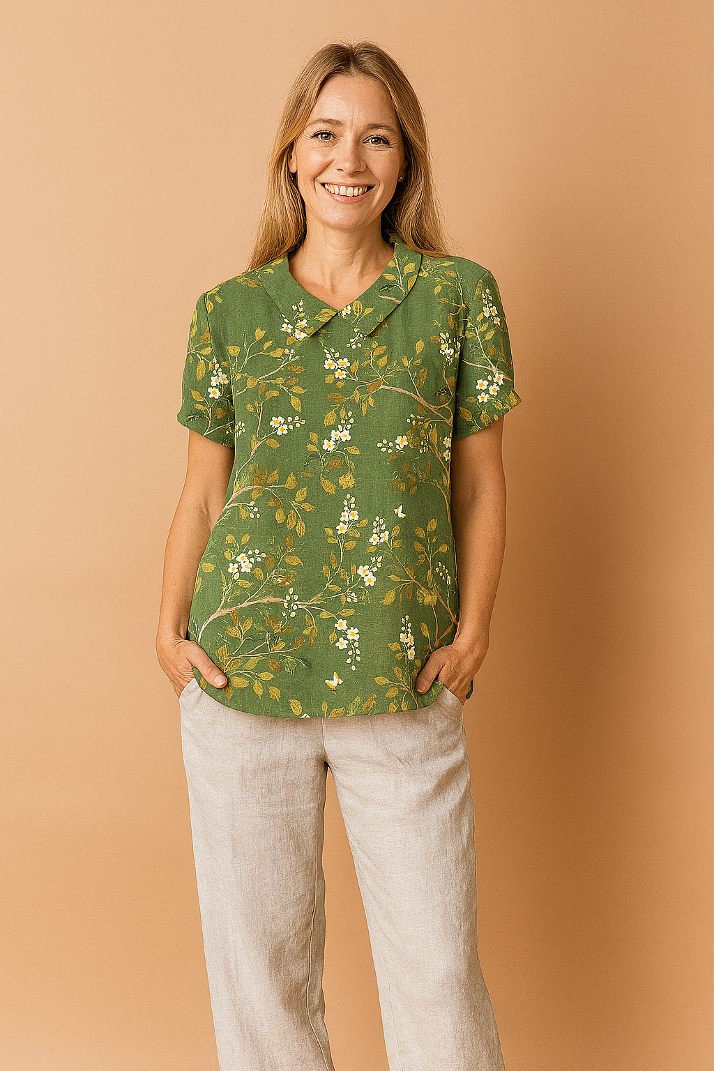 Donkergroene linnen blouse met korte mouwen, versierd met goudgele takken en witte bloesems in een sierlijk geborduurd patroon.