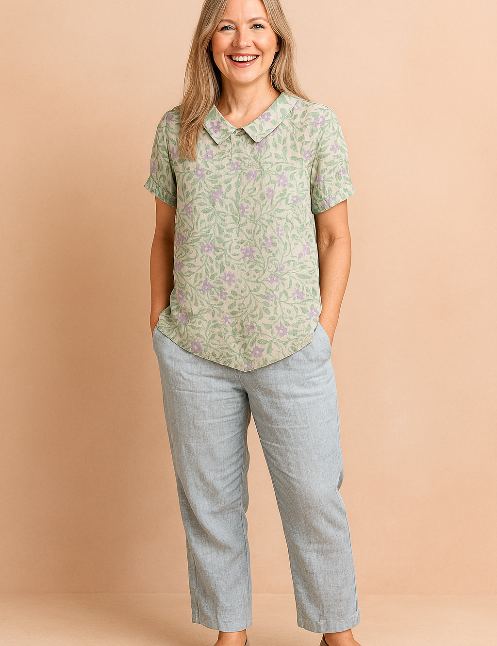 Zachtgroene blouse met korte mouwen en een lila blad- en bloemmotief in all-over print, afgewerkt met een ronde kraag.