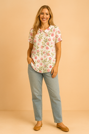 Blouse met korte mouwen en een witte basis, bedrukt met een patroon van roze rozenknoppen en groene bladeren in een zachte aquarelstijl.