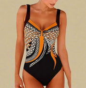 Zwart badpak met oranje en beige geometrische accenten en centrale twist