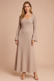 Vrouw met een beige kleurige geribde gebreide midi-jurk met lange mouwen, vierkante halslijn en uitlopende mouwen