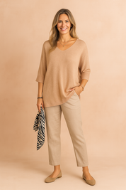 Comfortabele losvallende trui met V-hals en halflange mouwen, uitgevoerd in een fijne beige knit met lichte textuur. Ideaal voor een casual-chique look.