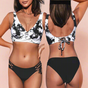 Zwart-wit tie-dye bikini met kruislingse twist-top en zwarte slip met open zijkanten en vetersluiting op de rug.