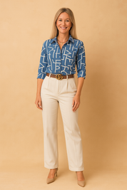 Blauw damesoverhemd met abstract wit lijnpatroon, lange mouwen en knoopsluiting, van lichtvallende stof.