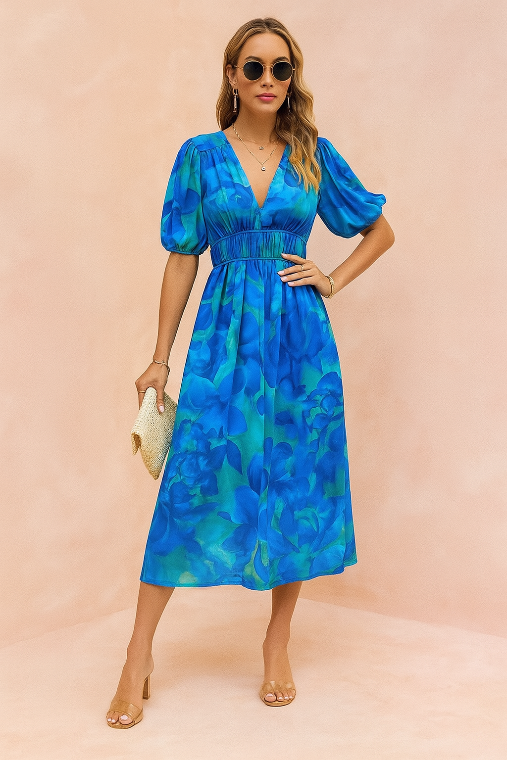 Blauwe midi-jurk met grote bloemprint, V-hals, pofmouwen en gesmokte taille.