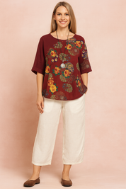 Bordeauxrode blouse met levendige geel-oranje bloemen- en medaillonprint, met relaxte korte mouwen en een vloeiende pasvorm voor moeiteloze boho-stijl.