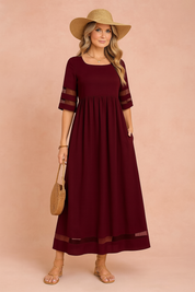 Bordeauxrode maxi jurk met transparante mouwdetails en luchtige voile afwerking, perfect voor zomerse dagen.