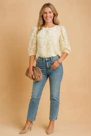 Botergele blouse met pofmouwen en een jacquard bloemenstructuur, voorzien van een klassieke ronde hals – perfect voor een frisse, zonnige look.