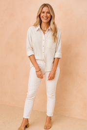 Crèmekleurige blouse met kraag, knopen en losvallend model – stijlvolle basis voor elke dag.