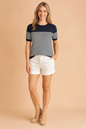 Dames T-shirt met korte mouwen en ronde hals, uitgevoerd in een kleurblokdesign met donkerblauw bovenstuk en mouwboorden, gecombineerd met een fijn horizontaal gestreept patroon in donkerblauw en wit over het voor- en achterpand. Gemaakt van een zachte, rekbare stof met een comfortabele, licht getailleerde pasvorm.
