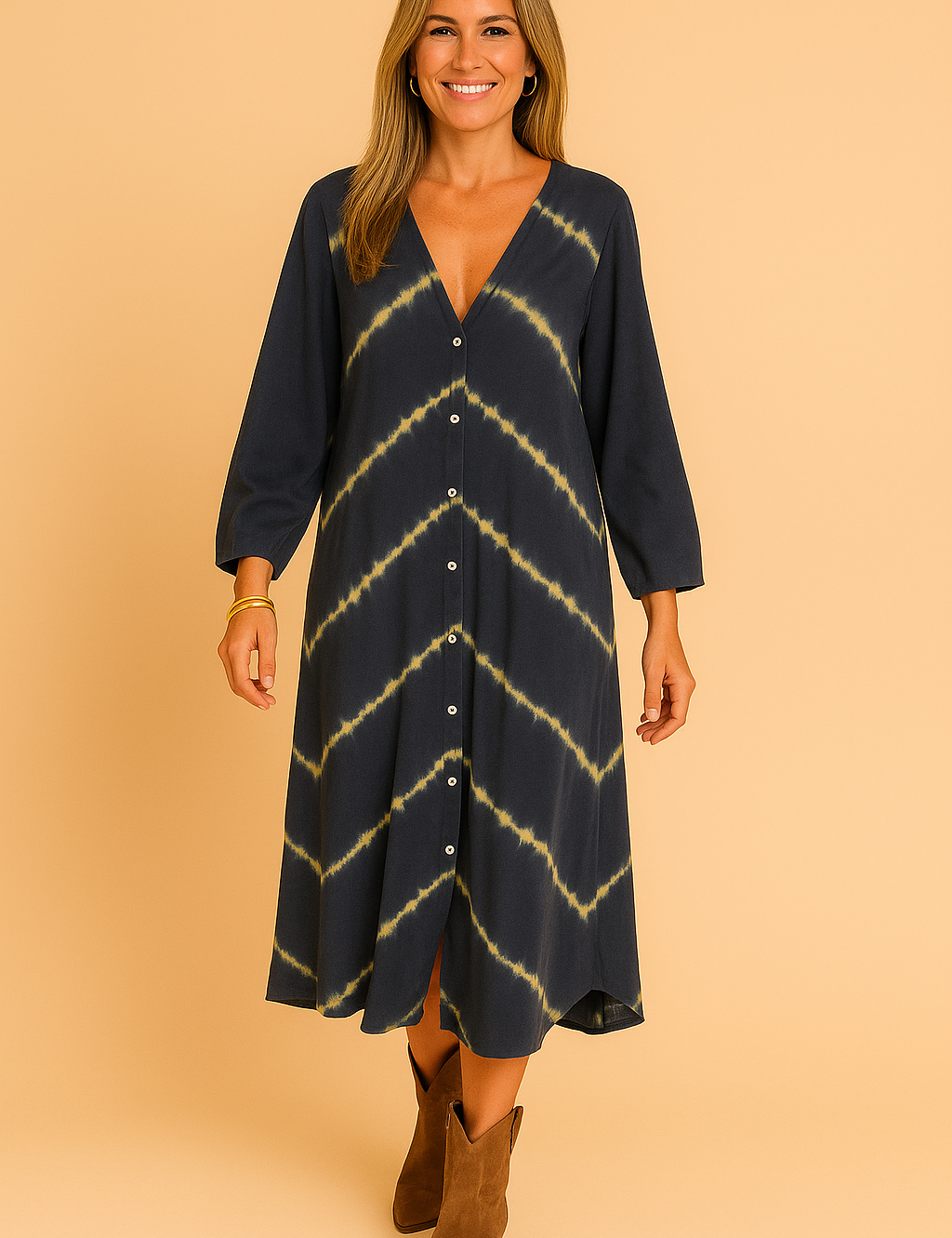 Donkerblauwe midi-jurk met lange mouwen, V-hals en volledige knoopsluiting, afgewerkt met diagonale tie-dye strepen in geel.