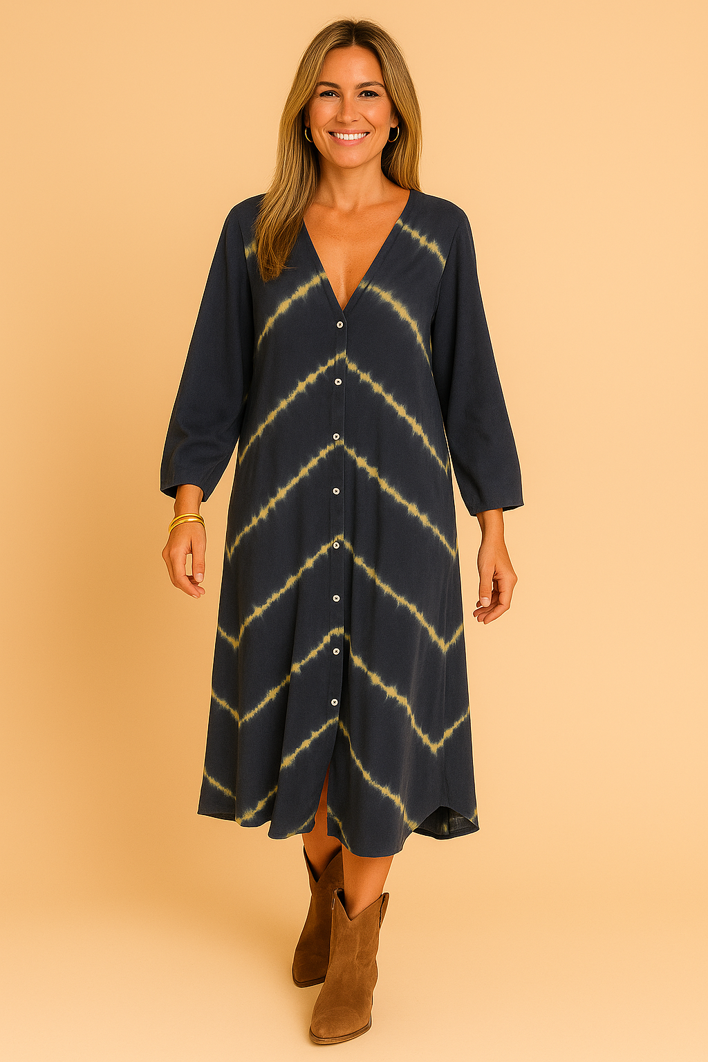 Donkerblauwe midi-jurk met lange mouwen, V-hals en volledige knoopsluiting, afgewerkt met diagonale tie-dye strepen in geel.