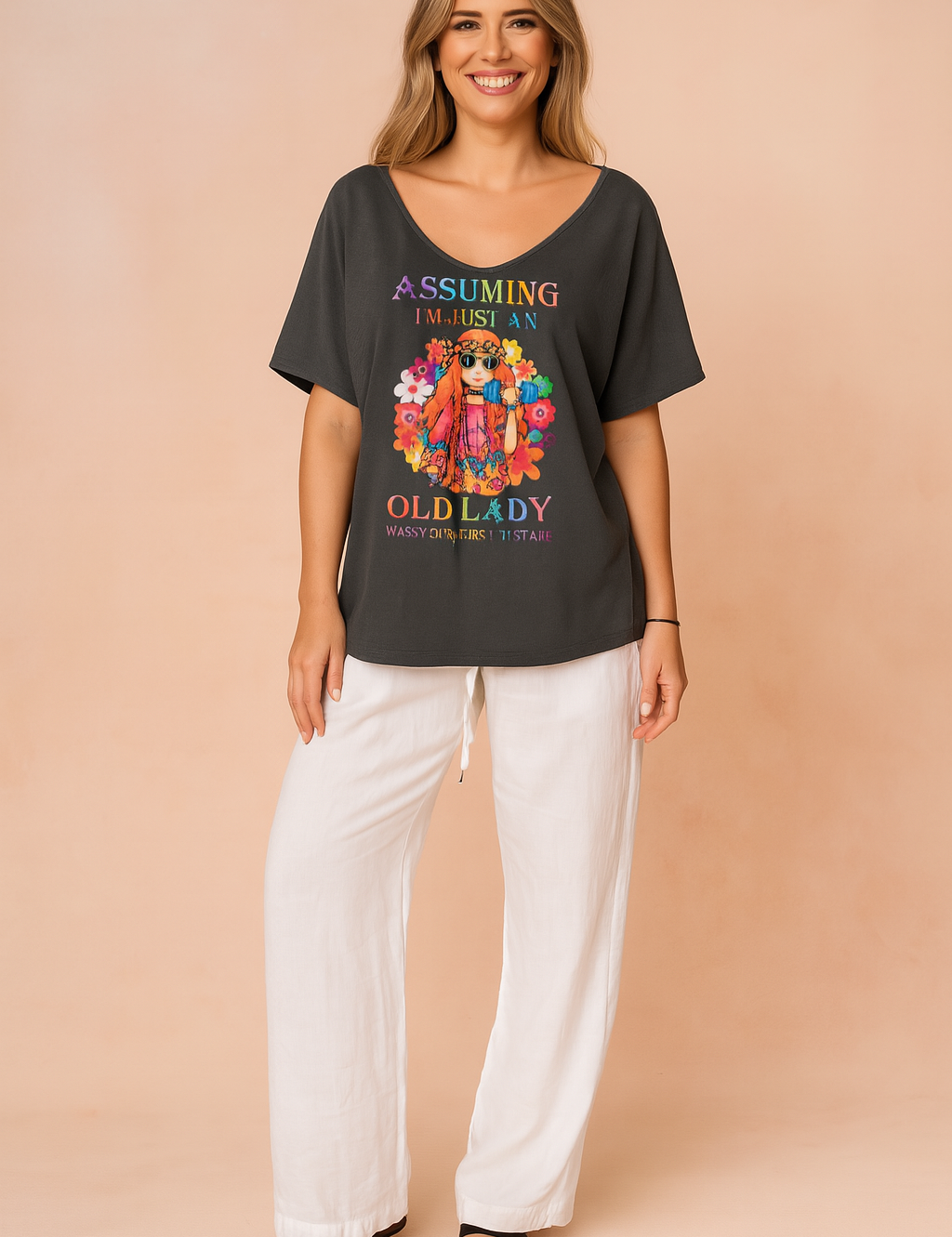 Donkergrijs dames-T-shirt met diepe V-hals, korte mouwen en kleurrijke hippie-print met de tekst “Assuming I’m just an old lady”, uitgevoerd in zachte, soepele stof voor een relaxte pasvorm.