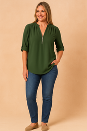 Donkergroene blouse voor dames met gladde textuur, een diepe V-hals met zilverkleurige rits, en 3/4-mouwen met vaste omslag en knoopdetail.