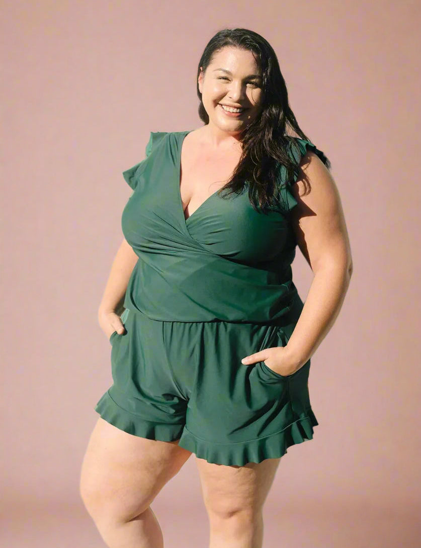 Donkergroene plus size wikkelromper met ruffle zomen en korte mouwen, flatterende pasvorm.