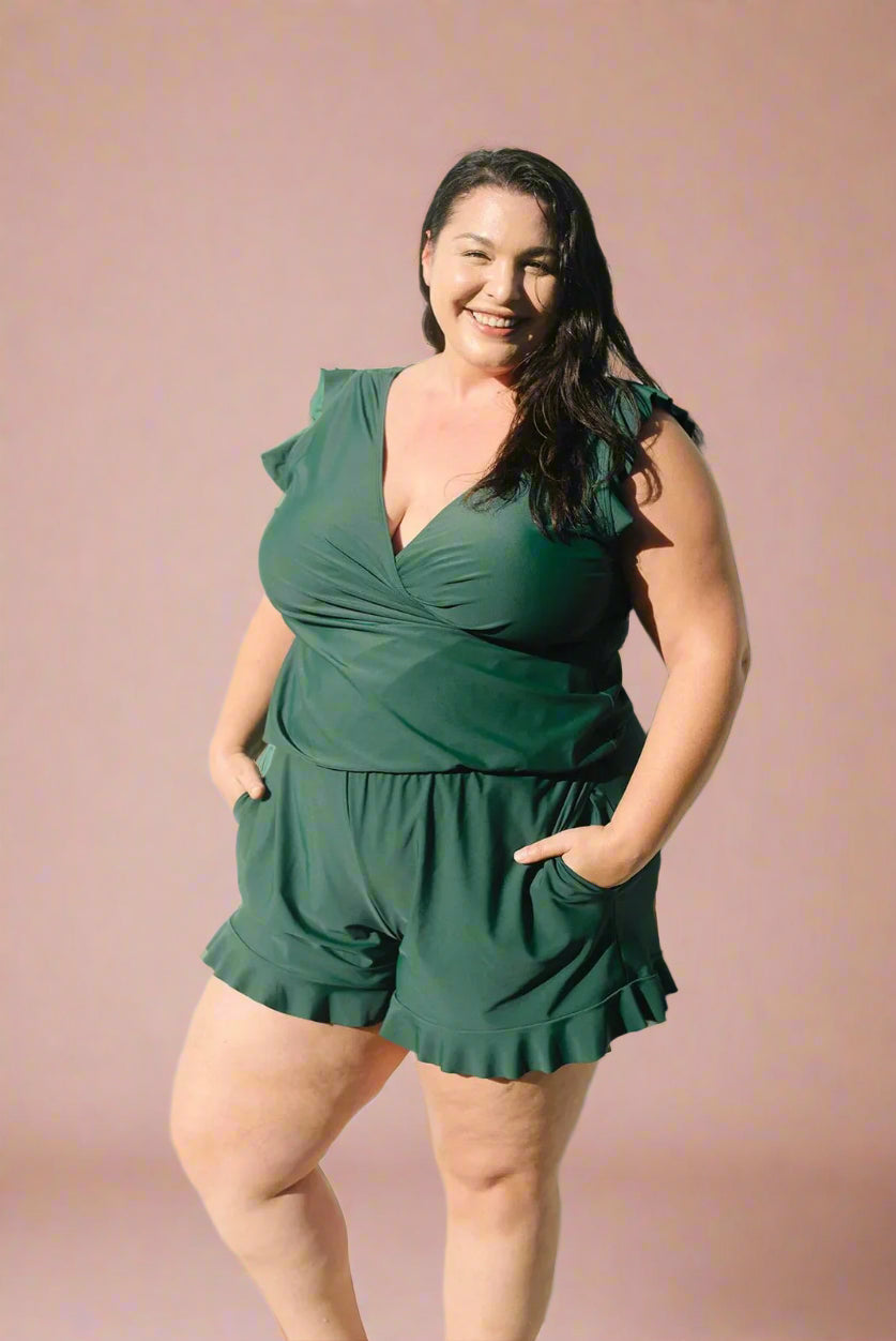 Donkergroene plus size wikkelromper met ruffle zomen en korte mouwen, flatterende pasvorm.