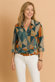 Damesoverhemd met knopen en opvallend geometrisch patchwork in teal, roest en beige, afgewerkt met borstzakken en opgerolde manchetten.