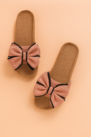 Geweven instapsandalen met oversized roze stoffen strikken en opvallende zwarte accenten, combineren comfort met speelse elegantie voor de zomer.