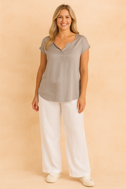 Lichtgewicht grijze blouse met korte mouwen, afgeronde zoom, soepele pasvorm en gedeeltelijke knoopsluiting aan de voorkant.
