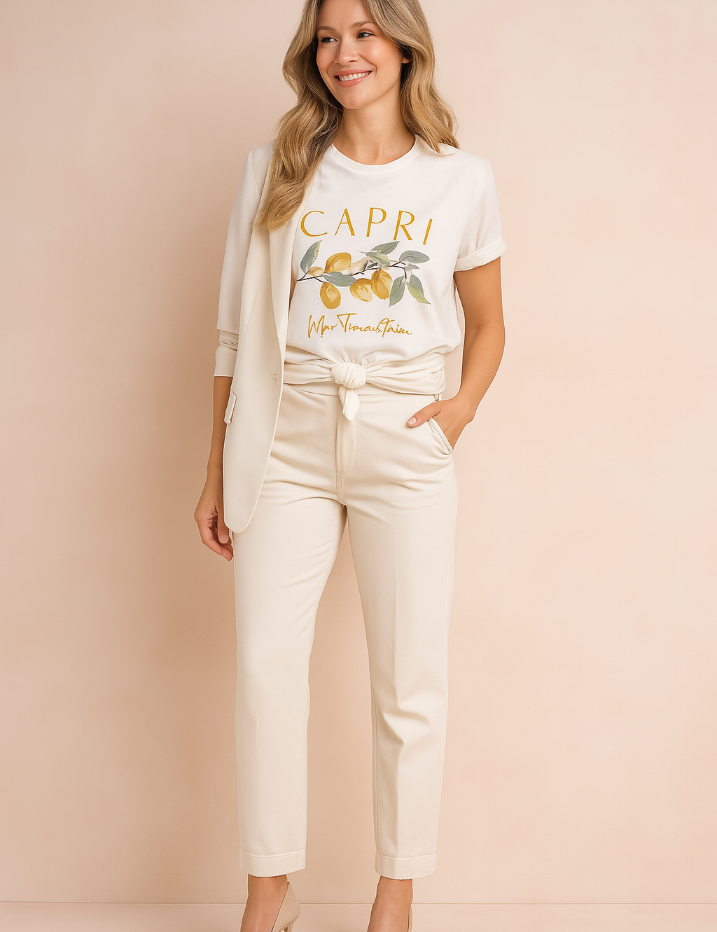 Wit T-shirt met citroenprint en “Capri”-opdruk in handgeschreven stijl, gecombineerd met een elegante crème outfit – frisse en verfijnde casual look.