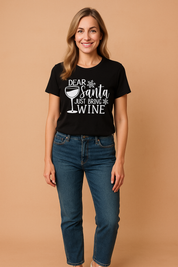 Zwart kerstshirt met witte tekst "Dear Santa Just Bring Wine" en wijnglasillustratie – perfect voor een casual feestlook.


