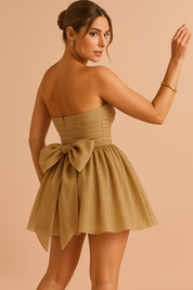 Gouden strapless mini-jurk met opvallende strikdetail op de rug