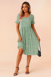 Groene midi bloemenjurk met korte mouwen en wit bloemetjespatroon, luchtig en vrouwelijk ontwerp.