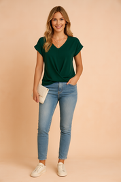 Groene damesblouse met V-hals en korte opgerolde mouwen, gemaakt van een gladde, effen stof met een elegante, licht gedrapeerde twist aan de voorzijde — ideaal voor een casual-chique outfit.