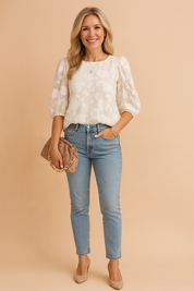 Ivoorkleurige jacquard blouse met subtiel bloemenpatroon, ronde halslijn en volumineuze pofmouwen voor een elegante daglook.
