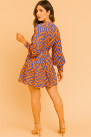 Korte jurk met oranje en paarse ikatprint, lange ballonmouwen, knoopsluiting en elastische taille, afgewerkt met een volantrok.