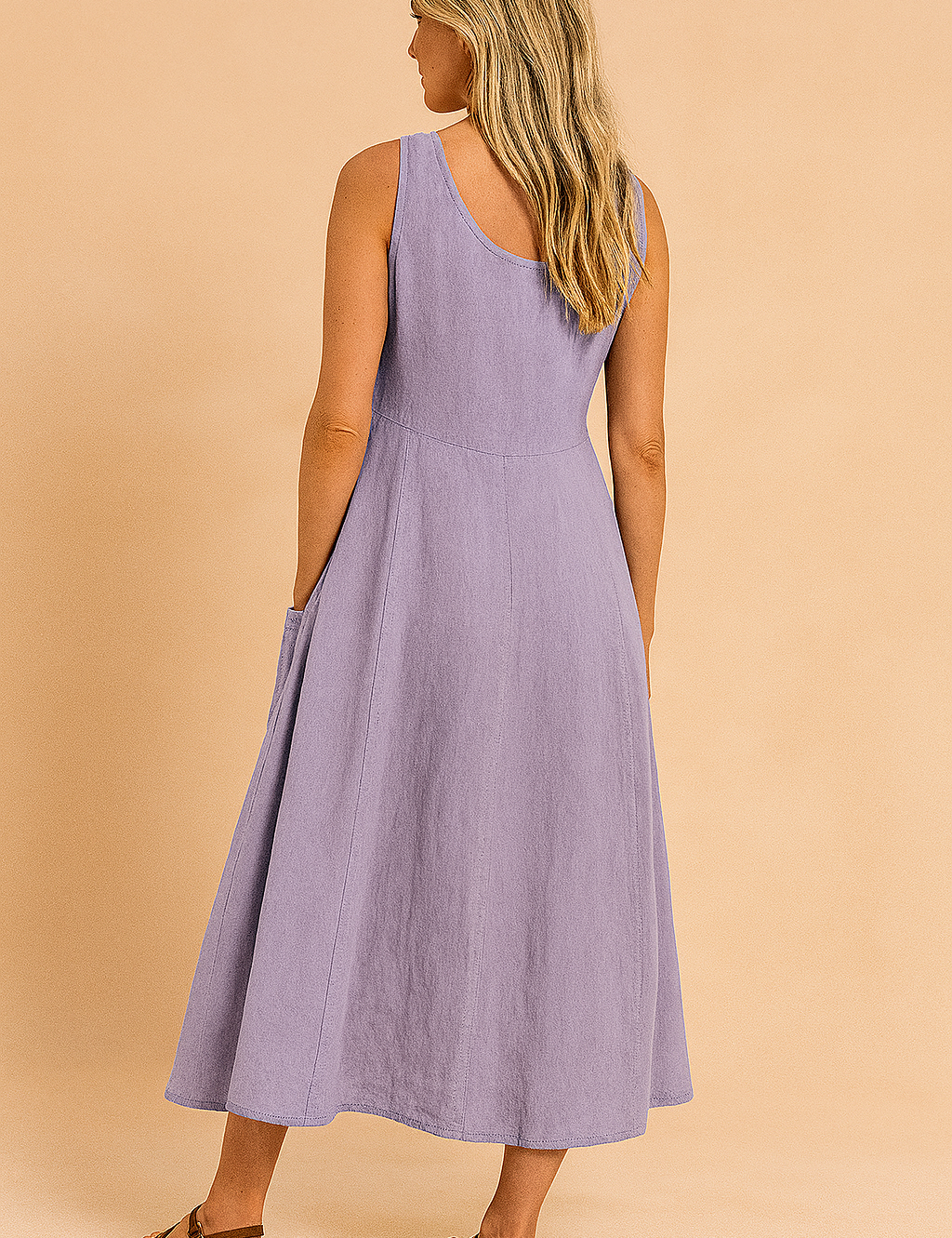 Mouwloze lavendelkleurige linnen midi-jurk met wijde A-lijn en diepe rug, ontworpen met steekzakken voor een luchtige zomerse look.