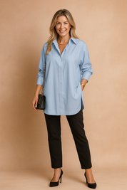 Losvallende blouse met lange mouwen in zachtblauw, voorzien van een verborgen knoopsluiting en een klassieke overhemdkraag. Perfect voor een luchtige, moderne stijl.