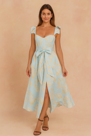 Lichtblauwe midi zomerjurk met gele bloemenprint, strikbandjes en split aan de voorkant