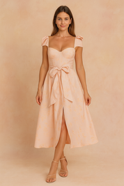 Mouwloze lichtroze midi zomerjurk met strikdetail en sweetheart halslijn