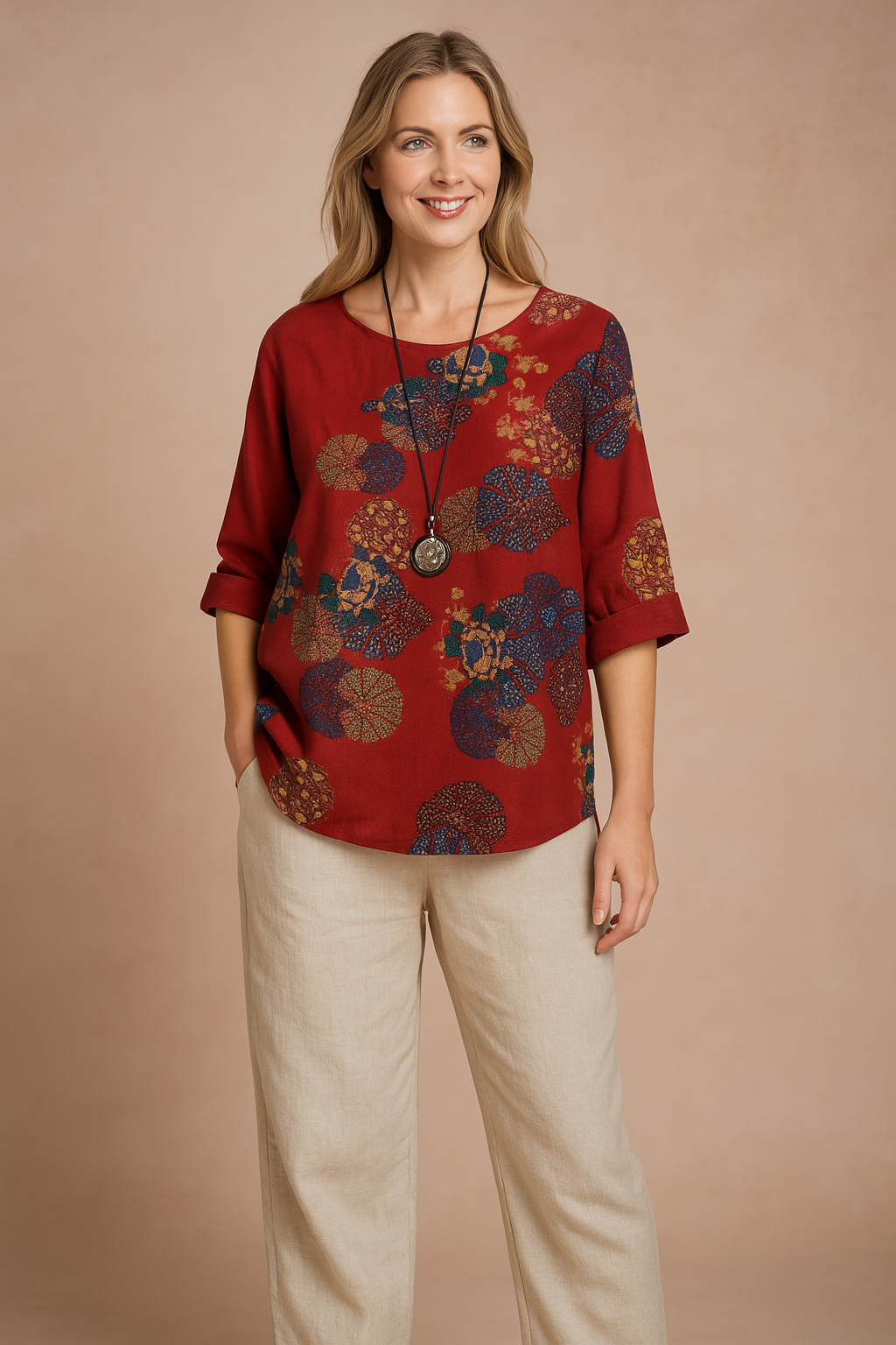 Ruimvallende rode blouse met ronde hals en opgerolde mouwen, met abstracte bloemenmedaillonprint in aardetinten en marineblauw. Perfect voor casual en boho-geïnspireerde outfits.