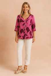 Magenta bloemenblouse met dieprode tulpenprint, V-hals, knoopsluiting aan de voorkant en omgeslagen driekwartmouwen voor een gedurfde maar vrouwelijke uitstraling.