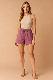 Losse mauve paarse shorts met hoge tailleband en verstelbaar trekkoord, gestyled voor moeiteloze elegantie.