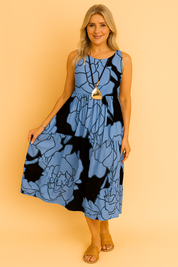 Mouwloze midi-jurk met denimblauwe en zwarte oversized bloemenprint, gelaagd en perfect voor casual zomerdagen.