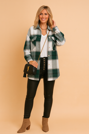 Groen-wit flanel damesoverhemd met zwarte accenten en borstzakken, lang model met knoopsluiting.