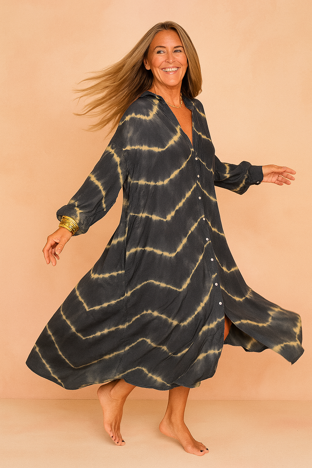 Oversized maxi jurk met tie-dye patroon in donkerblauw en beige, V-hals en knoopsluiting aan de voorkant.
