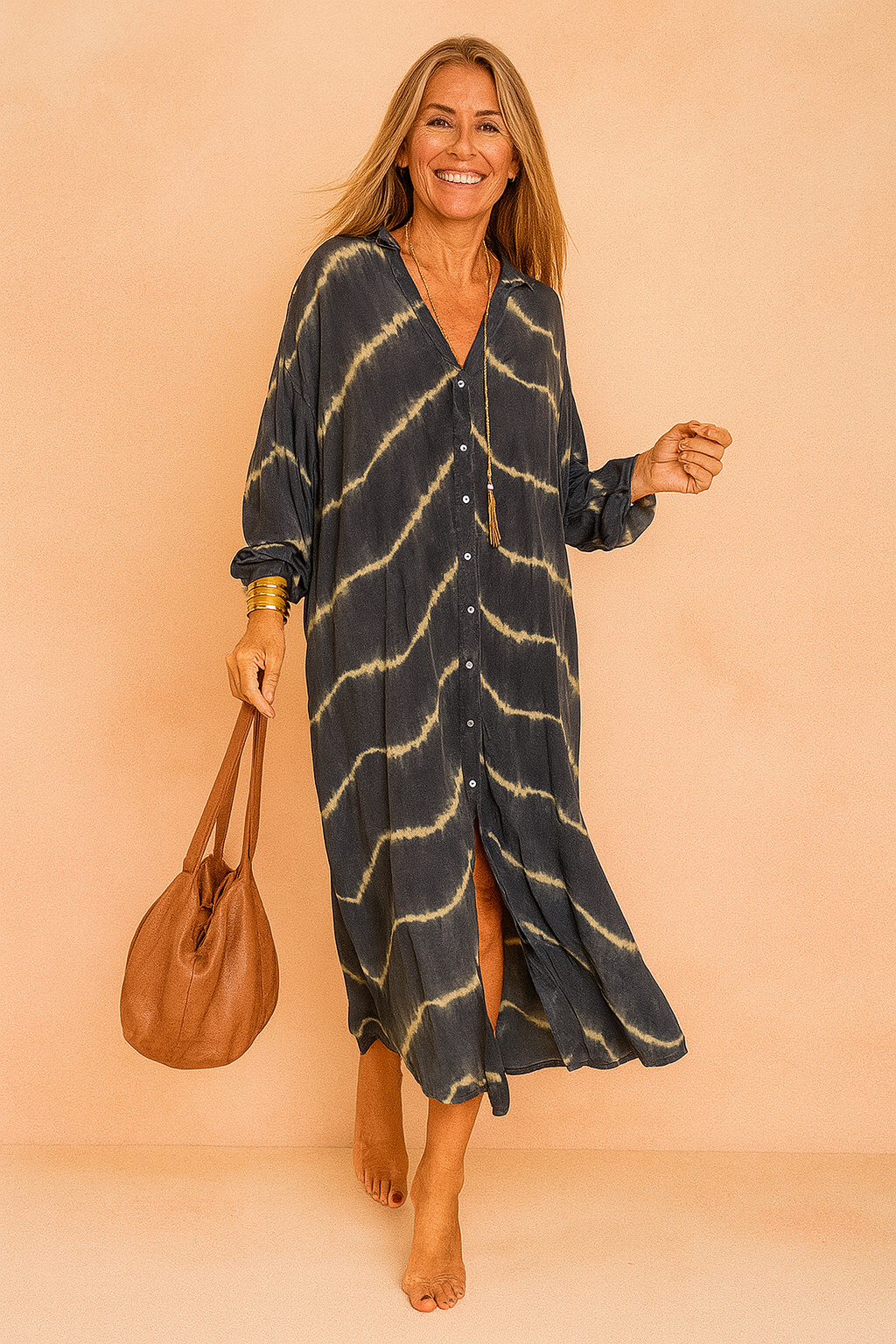 Oversized maxi jurk met tie-dye patroon in donkerblauw en beige, V-hals en knoopsluiting aan de voorkant.