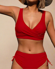 Rode bikini met gekruiste top en hoge taille bikinibroek met verstelbare zijkanten