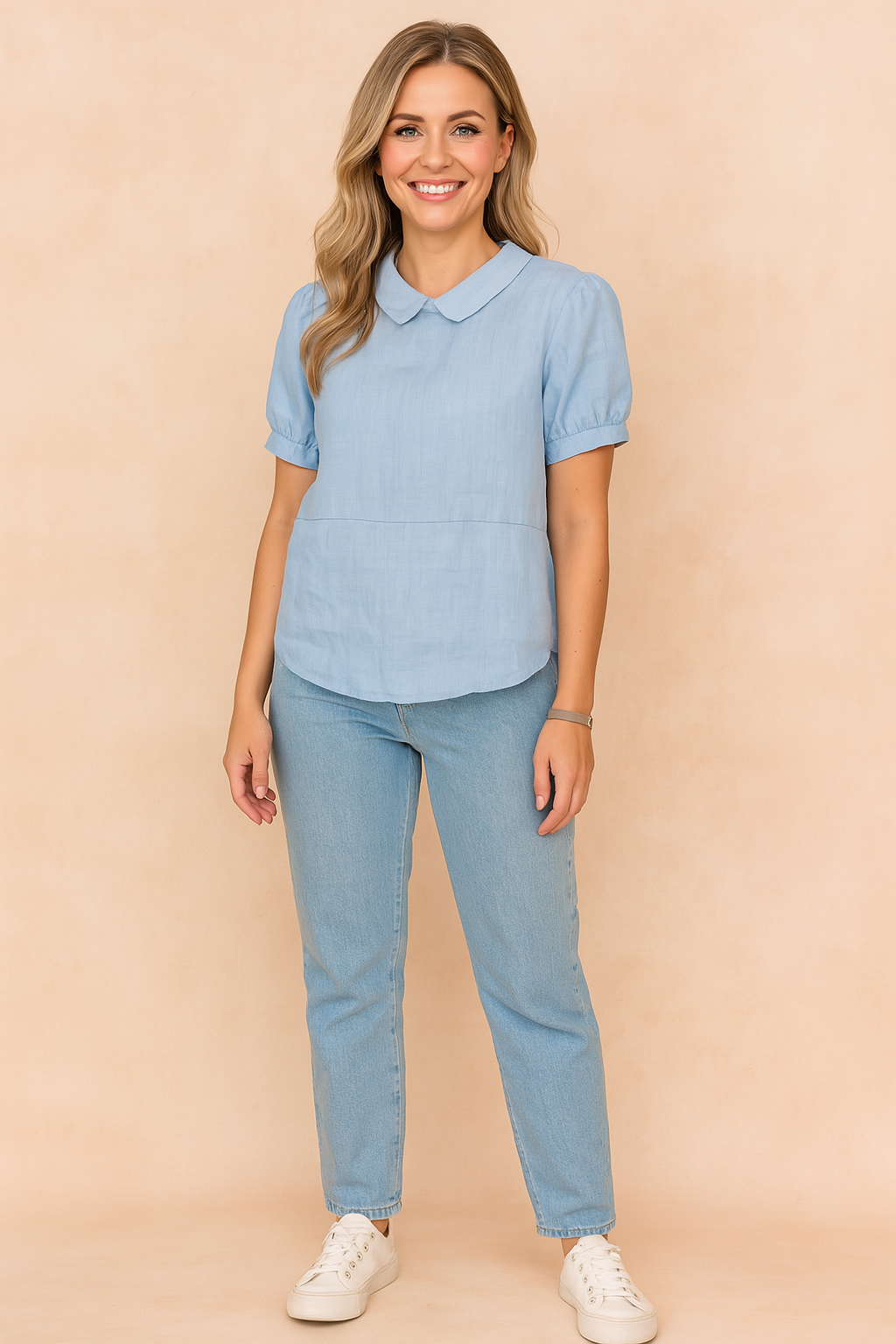 Lichtblauwe blouse met Peter Pan-kraag en korte pofmouwen, vervaardigd uit effen linnen-look stof.