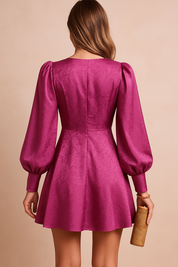 Mini-jurk met diepe V-hals en pofmouwen in fuchsia satijnlook, met A-lijn rok en tailleband.