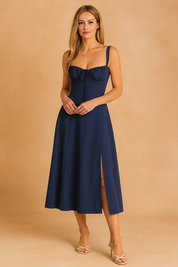 Marineblauwe bustier midi-jurk met vrouwelijke pasvorm, brede bandjes en elegante split.