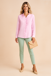 Lichtroze blouse met lange mouwen, verticale ribstructuur en speelse ruche langs de knopenlijst en kraag, in een effen, zachte stof.
