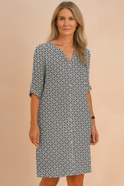 Grijs-witte overhemdjurk voor dames met all-over geometrisch patroon, V-hals en driekwartsmouwen.