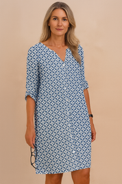 Zomerjurk met blauwe en witte cirkelprint, V-hals en opgerolde mouwen, knielang model.